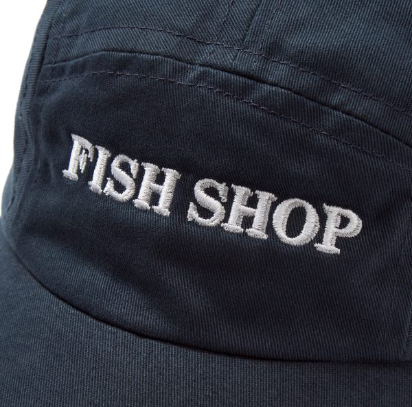 white embroidered fish shop logo on a navy blue cap